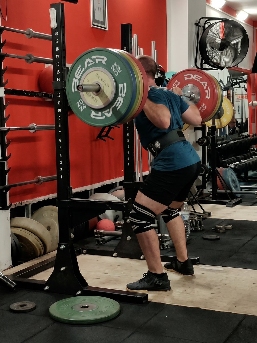 Squat con bilanciere carico durante una seduta di powerlifting